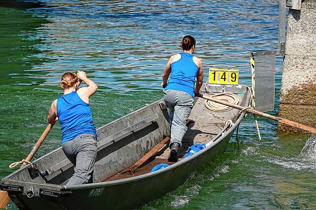 Frauenpower auf dem Rhein: Zwei Pontonierfahrerinnen an einem Brückenpfeiler.