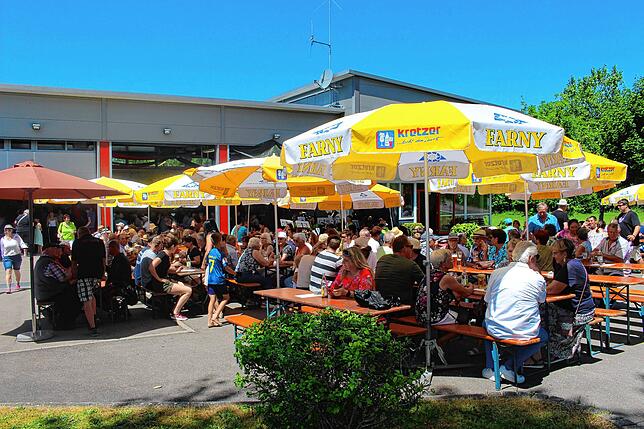 Rund um das Feuerwehrhaus wird bei strahlendem Sonnenschein kräftig gefeiert.