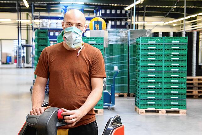 Vorarbeiter, George Serban, bringt in der Logistikhalle Gemüsekisten von A nach B.