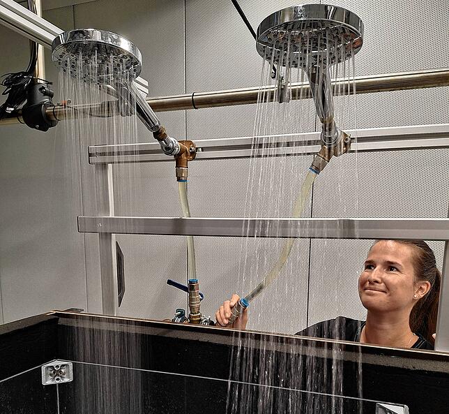 Die Kunst der leisen Berieselung: Melanie Grüner, Akustik-Ingenieurin bei Hansgrohe, in ihrem schalldichten Labor mit zwei Handbrausen ...