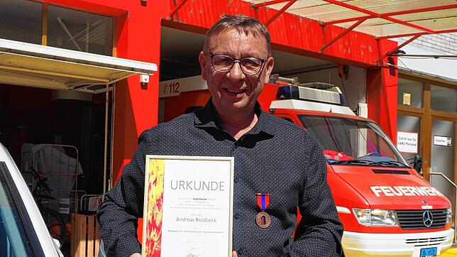 Andreas Brodbeck mit Urkunde und Medaille im Depot der Betriebsfeuerwehr der Varo im Binninger Hafen.