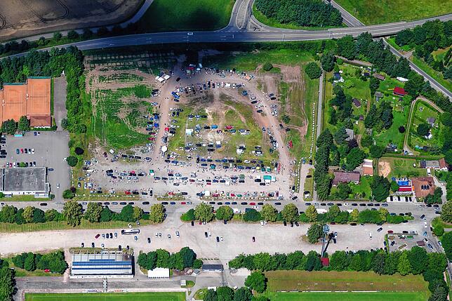 Diese Bild zeigt von oben einen Flohmarkt auf dem Friedengrund. Auf der Straße davor geht es dann oft chaotisch zu.