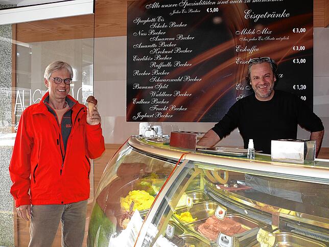 Wolfgang Schönwald gönnt sich ein Schokoladeneis bei der Eisdiiele Zandanel, rechts Inhaber Nini Zandanel.