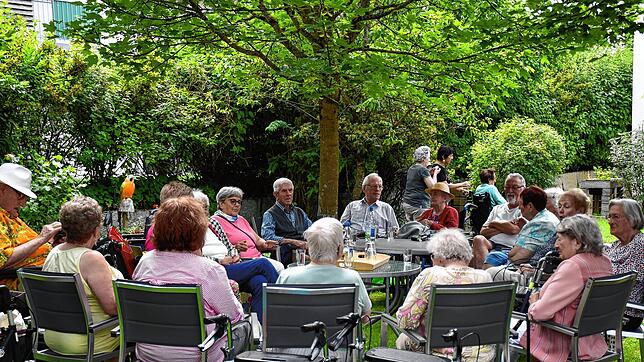 Im schattigen Garten des Pflegehauses genießen viele Bewohner und deren Angehörige den Schlagernachmittag.  Bilder: Gerd Jerger
