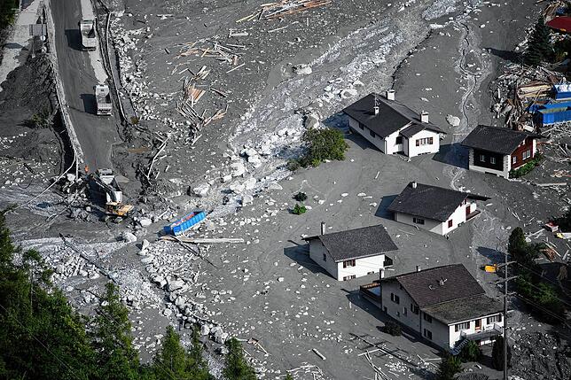 August 2017 in Bondo, Graubünden. Schlamm und Schutt werden von Lastwagen abtransportiert.