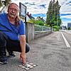 Thomas Kliebenschedel deutet auf den bislang einzigen Stolperstein in Friedrichshafen. Er befindet sich an der Zeppelinstraße in Fischbach.