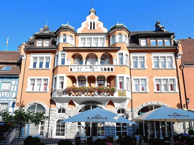 Die Adler Post heute. In der Mitte hinter dem Sonnenschirm des Eis-Cafés befindet sich der Haupteingang. Rechts ist das Eis-Café. Oben ...