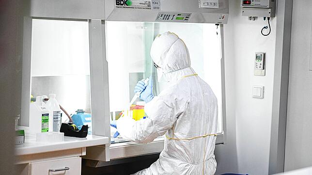 Ein Mitarbeiter des Labors Dr. Blessing in Singen bereitet unter der Sicherheitswerkbank ein Probenröhrchen für die Virus-Inaktivierung ...