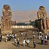 Die kolossalen Memnon-Statuen stehen vor der Tempelstadt von Luxor. Sie wurden aus Quarzit gefertigt und stellen Pharao Amenophis III. dar.