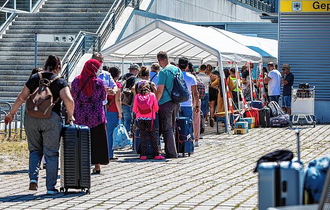 Reisende am Stuttgarter Flughafen warten vor dem Corona-Testzentrum. Seit Anfang August besteht die Testpflicht für Rückkehrer aus ...