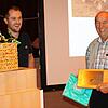 Michael Fecht überreicht Georg Oexle eine Urkunde und einen Geschenkkorb.