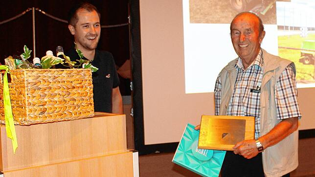 Michael Fecht überreicht Georg Oexle eine Urkunde und einen Geschenkkorb.