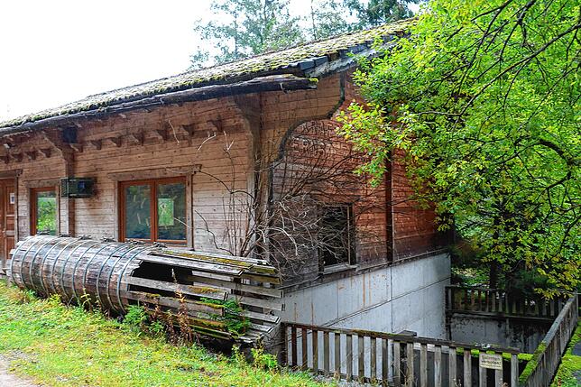 Das verkleinerte Modell einer Holzleitung liegt schon seit Jahren vor dem Turbinenhaus und löst sich langsam auf.