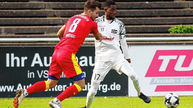 Denis Gudzevic (links, rotes Trikot) vom 1. CfR Pforzheim und Villingens Angreifer Ibrahima Diakité liefern sich einen harten Kampf um ...
