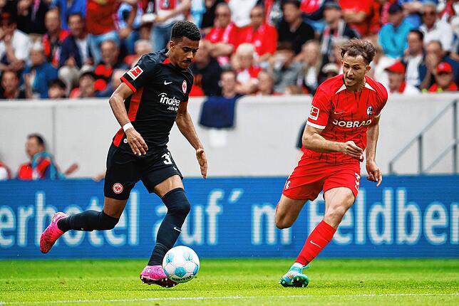 Frankfurts Ansgar Knauff (l) und Freiburgs Max Rosenfelder im Laufduell am Ball.
