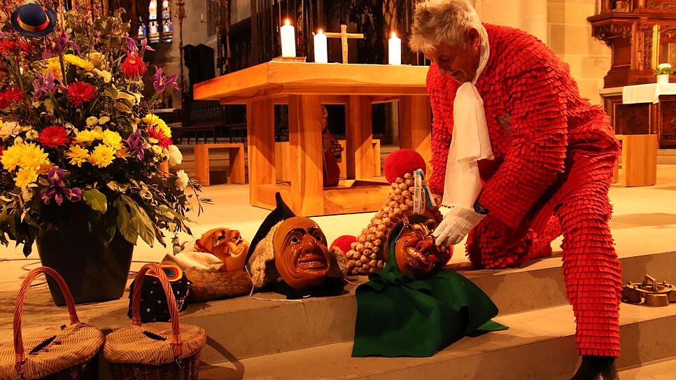 Ein Elzacher Schuttig legt seine Maske vor dem Altar ab, die Narrenmesse im Münster beginnt.