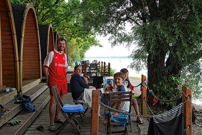 Familie Haindl aus Niederbayern auf der Terrasse direkt am See, die zu ihrer kleinen Blockhütte gehört.