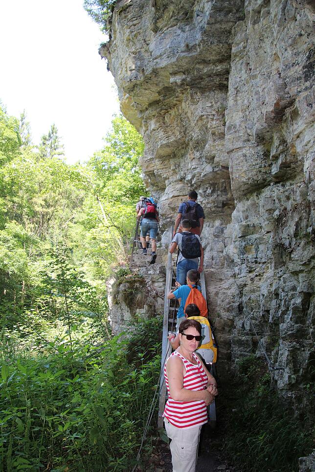 Wandersteig: Auf schmalen Wegen und teilweise über Gittertreppen führt der Weg an steil aufragenden Felsen vorbei.