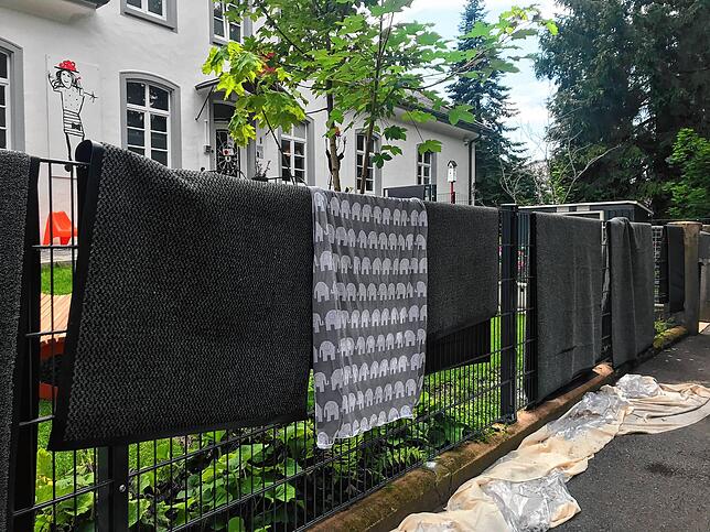 Die Teppiche hängen zum Trocknen über dem Zaun der Einrichtung. Kikripp-Mitarbeiter hatten versucht, damit Fenster und Türen abzudichten.
