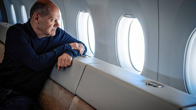 Bundeskanzler Olaf Scholz blickt aus dem Airbus A350 der Luftwaffe auf dem Rückweg von Tokio zum militärischen Teil des BER-Flughafens ...