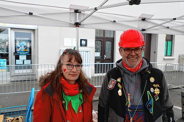 Die beiden freiwilligen Helfer Anette Schlobinski-Duscher (links) und Heinz Krahnen (rechts) verteilen Essen und Wasser an Personen auf ...