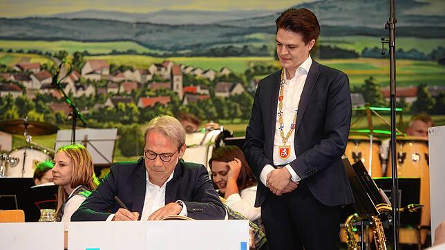 Der Eintrag ins Goldene Buch der Stadt: Gastredner Georg Maier schreibt, Bürgermeister Marian Schreier beobachtet.