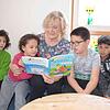 Omar, Safa, Irma und Subhanulla genießen es, wenn Lesepatin Hannelore Schooren ihnen vorliest. Bild: Jörg Büsche