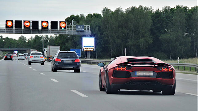 Ein Sportwagen fährt über eine Autobahn, auf der die Geschwindigkeit begrenzt ist.