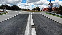 Die neu sanierte Straße Neuer Markt vor dem Kreisel an der Stadteinfahrt. Im Vordergrund Asphalt, im Hintergrund die Betonoberfläche. ...