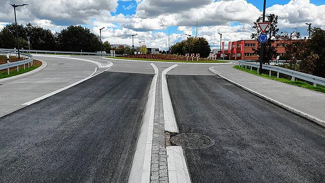 Die neu sanierte Straße Neuer Markt vor dem Kreisel an der Stadteinfahrt. Im Vordergrund Asphalt, im Hintergrund die Betonoberfläche. ...
