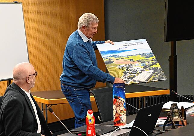 Willi Schirrmeister hat auch ein Luftbild der Kläranlage als Geschenk dabei. Auf der Rückseite sind Unterschriften der Belegschaft.