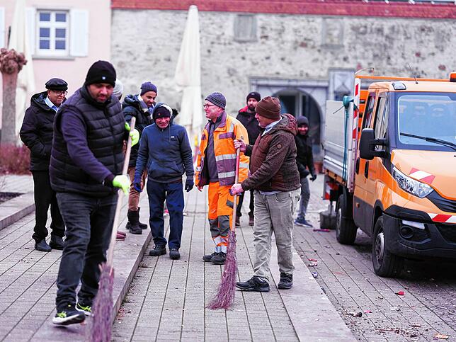 Günter Strasser (Mitte, in Orange) begrüßt die Helfer und erklärt den Ablauf, während Erfahrene vom Vorjahr bereits loslegen.