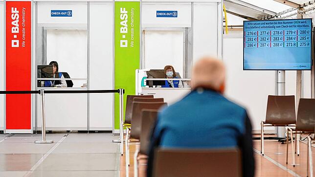 Ein geimpfter Mitarbeiter sitzt im BASF-Impfzentrum im Wartebereich, in dem mögliche Nebenwirkungen der Corona-Impfung beobachtet ...