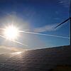 Ein Windrad steht hinter den Solarzellen einer Solarkraftanlage im Sonnenschein. Bis zu zwölf Windenergieanlagen können nach den ...