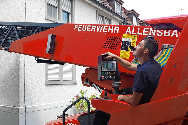 Konzentriert achtet Maschinist Sven Welschinger in seinem Sitz neben dem Drehkranz darauf, was die Mannschaft im Korb anstellt.