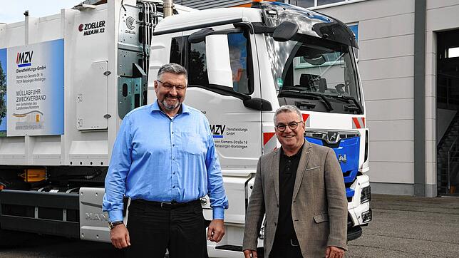 MZV-Geschäftsführer Martin Zimanky und Bürgermeister Ralf Baumert vor einem der beiden neuen Pressmüllfahrzeuge.