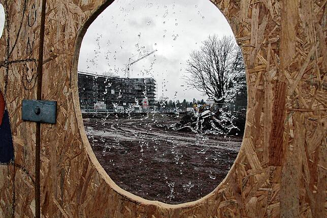Blick durch ein Sichtfenster im Bauzaun für Kinder.