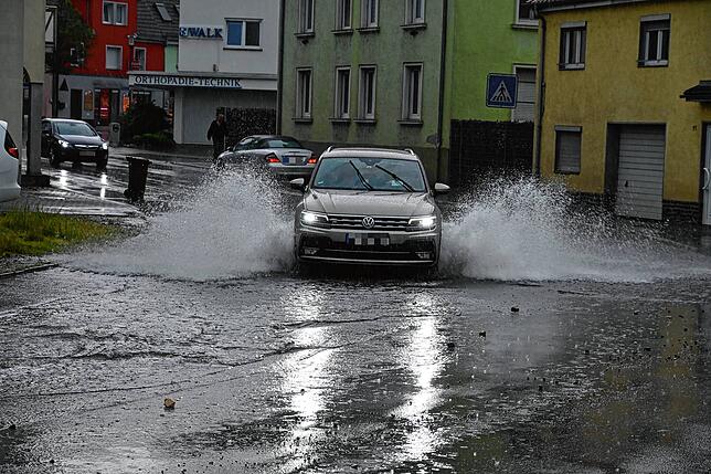 Dieses Auto fährt sehr schnell durch die Wasseransammlung.
