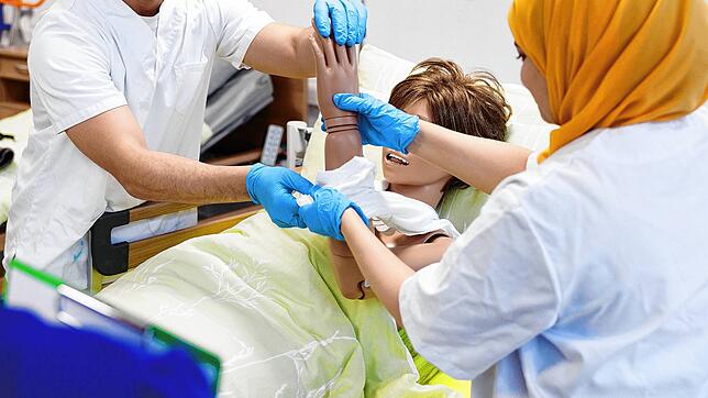 Eine ausländische Pflegekraft bei einem Praxistraining in einer Klinik.