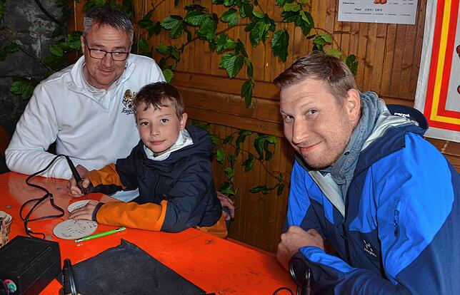 Hier werden Star-Wars-Roboter in Holz eingebrannt. Hardy Frick leitet an, Lukas brennt und Vater Michael Freitag freut sich über das ...