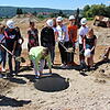 Schulleiterin Cosima Breitkopf legt die Zeitkapsel in das Loch vor der Baugrube der neuen Gottmadinger Schule. Schülerinnen und Schüler, ...