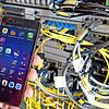 Ein Techniker hält ein Smartphone in einer Mobilfunkstation. Ein defektes Bauteil in einer solchen Station störte das Handynetz in ...