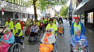 Die grüne Farbe zieht sich durch: Unter dem Motto „Laufend mithelfen“ ist das Altenheim St. Anna beim Stadtlauf 2025 zum Teil rollend ...
