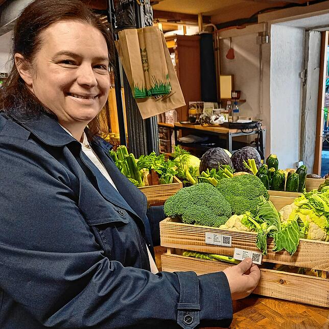 Der QR-Code an der Gemüsekiste: Nicole Claußnitzer zeigt, wie sie jedes einzelne Produkt – hier Brokkoli und Blumenkohl – mit einem ...
