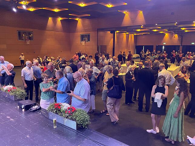 Das Publikum blickt gespannt auf die ersten Ergebnisse in der Stadthalle Waldshut. Viele verfolgen das Geschehen auch im ...