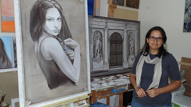 Die Malerin Elena Romanzin mit zwei ihrer Grisaille-Gemälde, die in der Ausstellung „Neue Romantik“ zu sehen sein werden. Bild: Michael ...