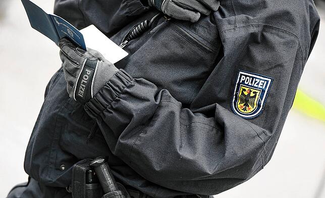 Ein Polizist überprüft Personalien.