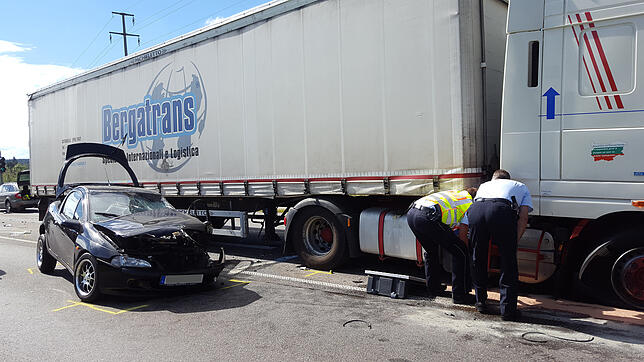 Die Verkehrspolizei begutachtet den LKW, der mit dem schwarzen Fahrzeug zusammengestoßen ist.