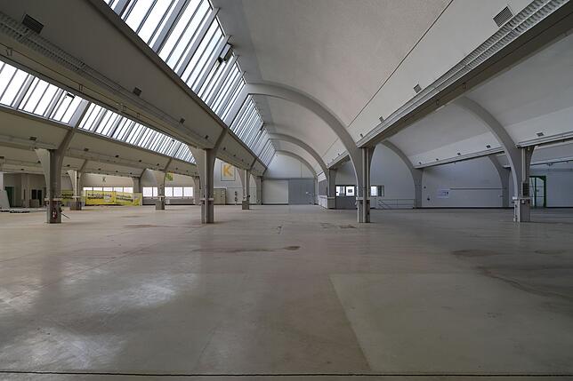 Durch die breiten Fensterbänder fällt viel Licht in die Halle, die hellen gerundeten Elemente verteilen es über den ganzen Raum. Wegen ...