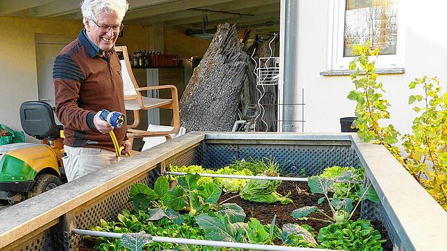 Fidelis Krall gießt die Hochbeete in seinem Garten mit dem Wasser aus seiner Zisterne.